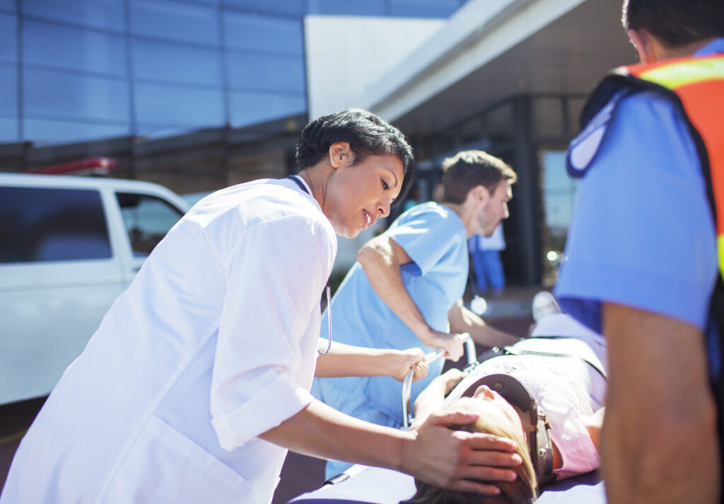 Doctor, nurse and paramedics wheeling patient to hospital