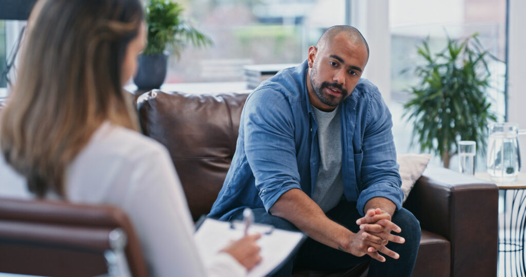 Cropped shot of a handsome young man looking thoughtful while sitting in session with his female therapist