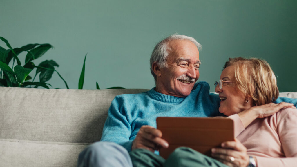 A portrait of a senior love couple relaxing at home, talking, reading, cuddling, enjoying